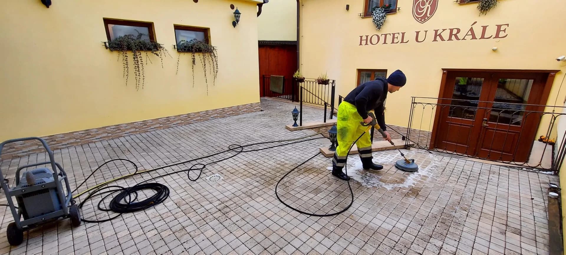 Čištění zámkové dlažby na nádvoří hotelu rotačním čističem.